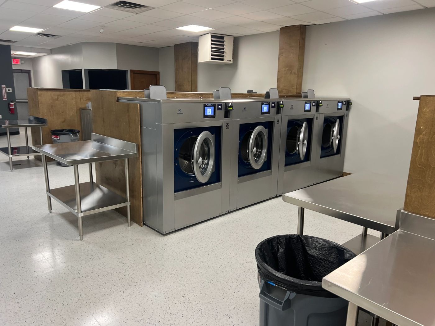 Big-drum navy Electrolux washers numbered along the wall at Clean Sheets